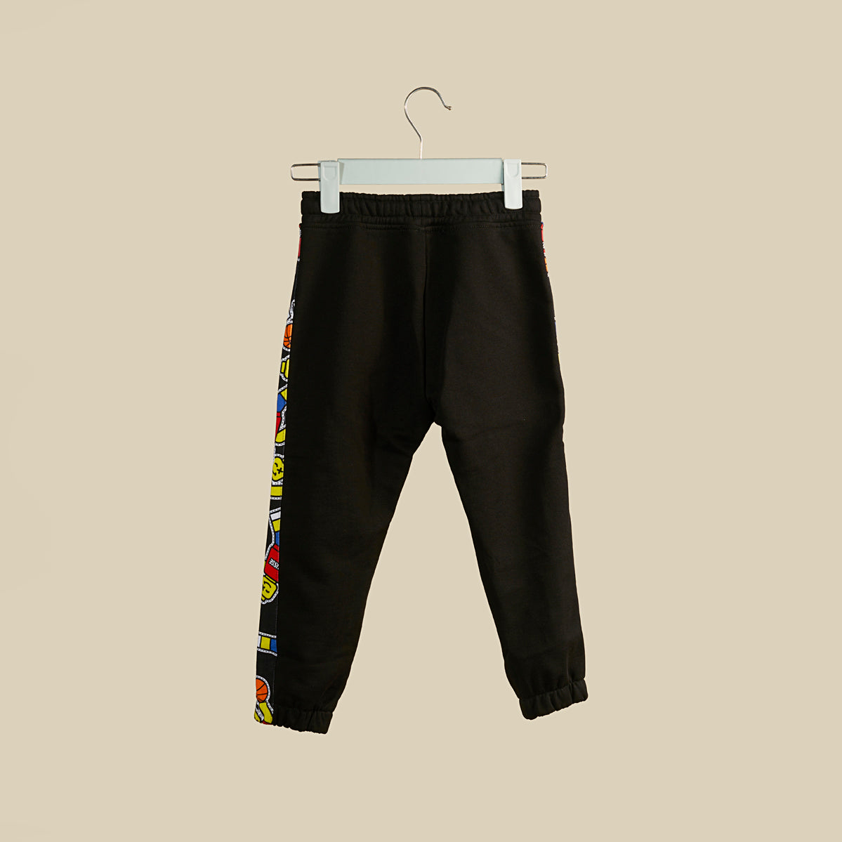 Pantalone jogger in tuta nera con banda laterale con stampe omini