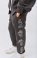 Pantalone in tuta grigia con simboli sui fianchi